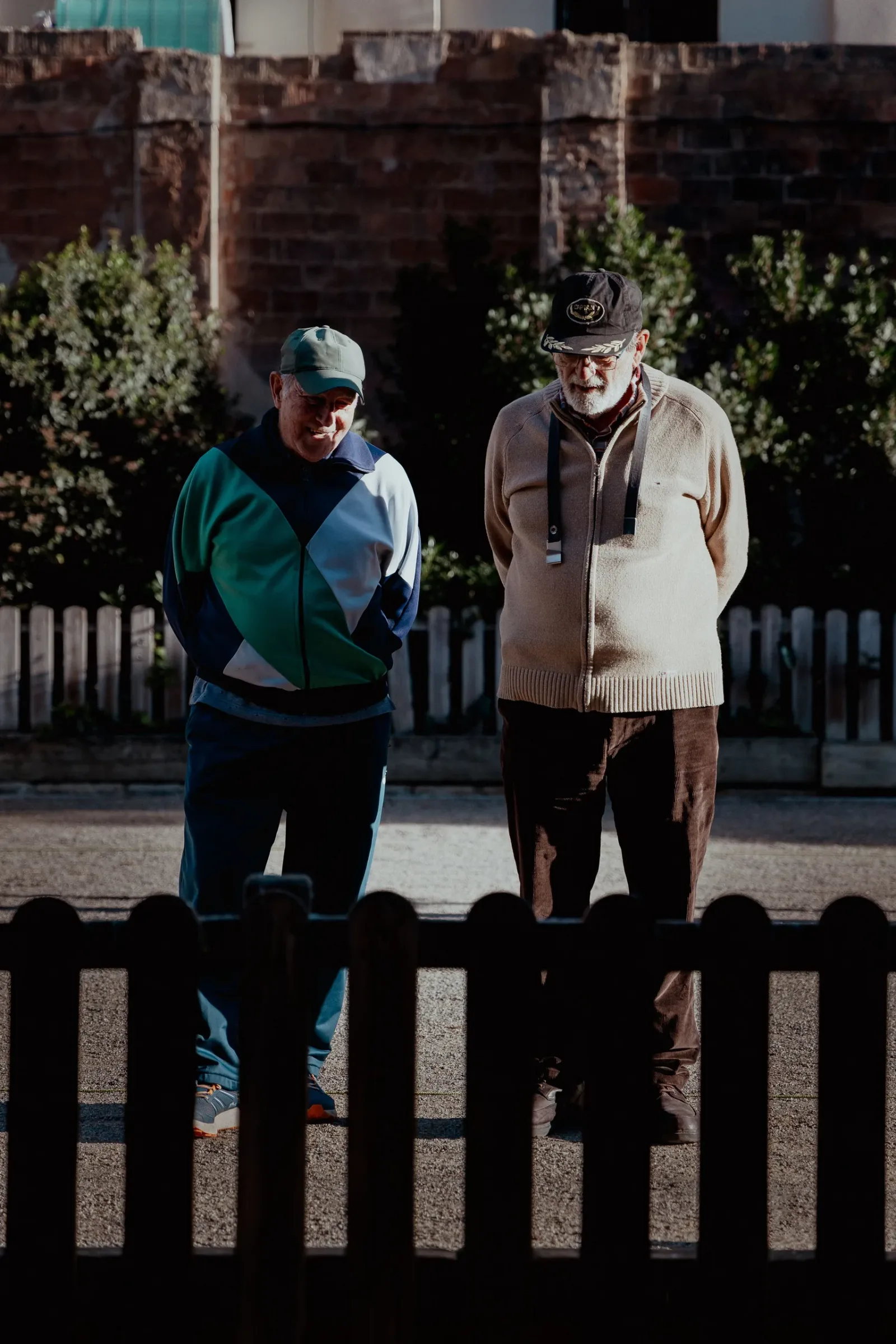Two older adults walking together through a sunny neighborhood