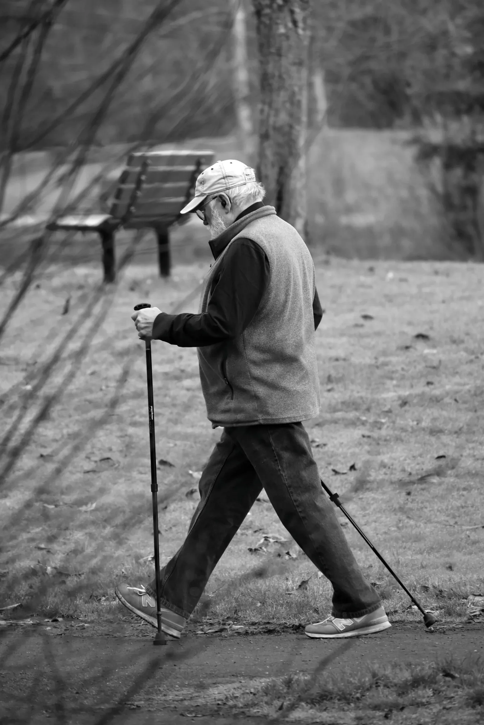 Older adult walking outdoors with trekking poles